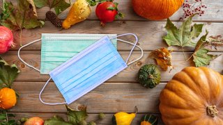 Thanksgiving 2020, coronavirus days, Protective face mask and thanksgiving flatlay on wooden background. COVID 19 spread prevention measure