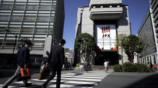 Pedestrians cross a road in front of the Tokyo Stock Exchange (TSE), operated by Japan Exchange Group Inc. (JPX), in Tokyo, Japan, on Thursday, Oct. 29, 2020.