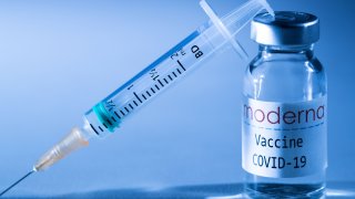 This creative image taken in a studio in Paris on November 16, 2020, showing a syringe and a vaccine vial with the reproducted logo of a US biotech firm Moderna, illustrates the announcement of an experimental vaccine against Covid-19 from Moderna that would be nearly 95% effective, marking a second major step forward in the quest to end the Covid-19 pandemic.