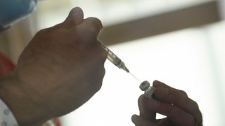 A syringe is filled from a vial of the Pfizer-BioNTech Covid-19 vaccine as it is prepared to be administered to front-line health care workers in Reno, Nevada on Dec. 17, 2020.