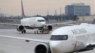 An Air Canada Boeing 737 MAX 8 aircraft is being towed in as another Air Canada Boeing 737 MAX 8 aircraft is seen on the ground at Toronto Pearson International Airport in Toronto, Ontario, Canada, March 13, 2019.
