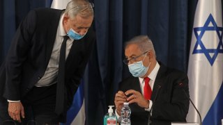Israeli Prime Minister Benjamin Netanyahu (R) speaks with Alternate PM and Defence Minister Benny Gantz, both wearing protective mask due to the ongoing COVID-19 pandemic, during the weekly cabinet meeting in Jerusalem on June 7, 2020. - Netanyahu urged world powers to reimpose tough sanctions against Iran, vowing to curb Tehran's regional "aggression" hours after another deadly strike on pro-Iranian fighters in Syria. (Photo by Menahem KAHANA / AFP)