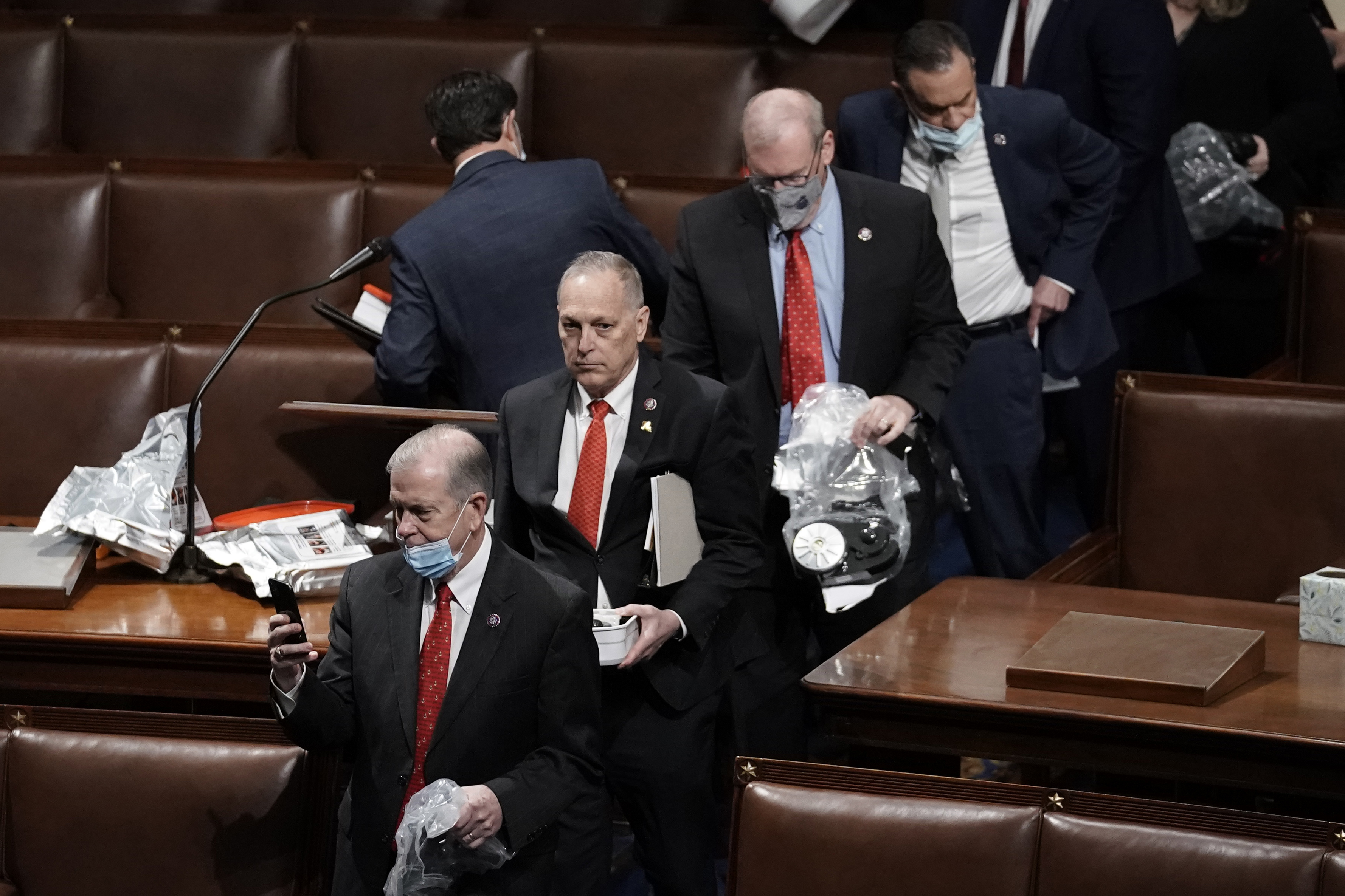 House of Representatives members leave the floor of the House chamber as protesters try to break into the chamber at the U.S. Capitol on Wednesday, Jan. 6, 2021, in Washington, DC.