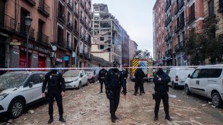Police officers cordon off Toledo Street following an explosion in downtown Madrid