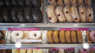 Doughnuts are displayed for sale inside a Dunkin' location