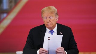 US President Donald Trump holds papers during an American Workforce Policy Advisory Board Meeting in the East Room of the White House in Washington, DC on June 26, 2020