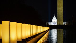 The U.S. Capitol, center, and Washington Monument, right, as lights surround the Lincoln Memorial Reflecting Pool during a Covid-19 memorial to lives lost on the National Mall in Washington, D.C., U.S., on Tuesday, Jan. 19, 2021. President-elect Joe Biden arrived in Washington on the eve of his inauguration with the usual backdrop of celebrations and political comity replaced by a military lockdown.