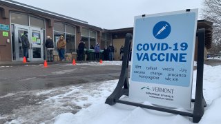 A line of people wait outside in Vermont for a coronavirus vaccine.