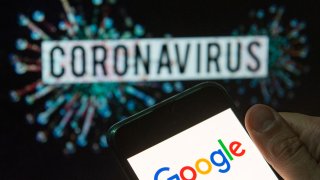 In this photo illustration the American multinational technology company and search engine Google logo seen displayed on a smartphone with a computer model of the COVID-19 coronavirus on the background.