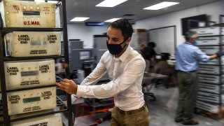 Electoral workers are seen during the vote-by-mail ballot scanning process at the Miami-Dade County Election Department in Miami, Florida on November 3, 2020. -