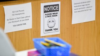 West Lawn, PA - October 22: A sign in a classroom that reads "Notice, please wear a face mask. Thank you" next to signs about rules of cell phone usage in class. At Wilson High School in West Lawn, PA Thursday afternoon October 22, 2020 where the school has been taking precautions for students doing in person school to prevent the spread of Coronavirus / COVID-19.