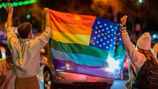 In this Nov. 7, 2020, file photo, people wave a rainbow flag as they celebrate the victory of Joe Biden in the 2020 presidential election in West Hollywood, California.