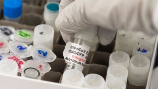 Dr. Nita Patel, Director of Antibody discovery and Vaccine development, lifts a vial with a potential coronavirus, COVID-19, vaccine at Novavax labs in Gaithersburg, Maryland on March 20, 2020, one of the labs developing a vaccine for the coronavirus, COVID-19.