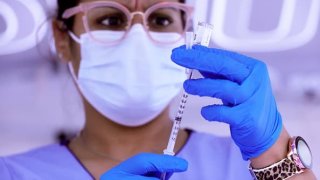 Nurse holds syringe of coronavirus vaccine