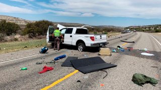 In this March 15, 2021, file photo, debris is strewn across a road near the border city of Del Rio, Texas after a collision. Eight people in a pickup truck loaded with immigrants were killed when the vehicle collided with an SUV following a police chase, authorities said.