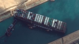 In this March 26, 2021, file photo, the cargo ship MV Ever Given is stuck in the Suez Canal near Suez, Egypt. A maritime traffic jam grew to more than 200 vessels Friday outside the Suez Canal and some vessels began changing course as dredgers worked frantically to free a giant container ship that is stuck sideways in the waterway and disrupting global shipping.
