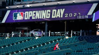 A worker cleans seats to prepare Coors Field for the return of fans in the era of the coronavirus during a news conference Wednesday, March 31, 2021, at the stadium in downtown Denver. A small number of fans were allowed to watch the Rockies go through a workout Wednesday before the team hosts the Los Angeles Dodgers in the squads' season-opener Thursday, April 1.