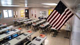 Carrizo Springs, TX- FEB 21: Text books and notebooks line tables inside a classroom at a Influx Care Facility (ICF) for unaccompanied children on Sunday, Feb. 21, 2021 in Carrizo Springs, TX. Children will begin arriving Monday before being placed with a government approved sponsor. The facility has dorm like rooms with areas for eating, bathing, and even hair cuts and laundry.