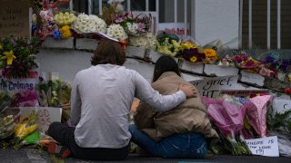 People bring flowers to the memorial sight set up outside of The Gold Spa on March 19, 2021 in Atlanta, Georgia.