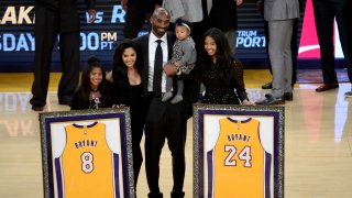 Kobe Bryant poses with his family at halftime after both his #8 and #24 Los Angeles Lakers jerseys are retired at Staples Center on December 18, 2017 in Los Angeles, California.