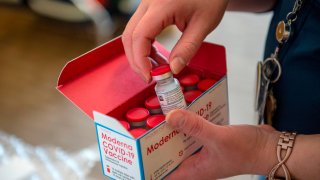 In this Dec. 24, 2020, file photo, RN Courtney Senechal unpacks a special refrigerated box of Moderna COVID-19 vaccines as she prepared to ready more supply for use at the East Boston Neighborhood Health Center (EBNHC) in Boston, Massachusetts.