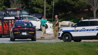 Police talk near the scene of a shooting at a business park in Frederick