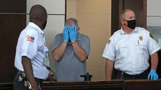 This Aug. 13, 2020, file photo shows Patrick Rose cover his face during his arraignment at Boston Municipal Court