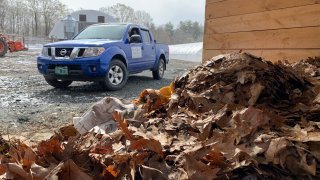 A pile of compost with a pickup truck in the background in Vermont.
