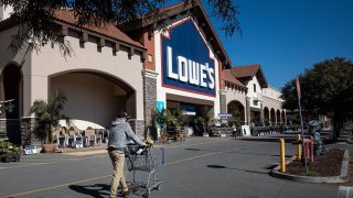 A customer pushes a shopping cart towards the entrance of a Lowe’s store in Concord, California, on Tuesday, Feb. 23, 2021.