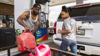 A man fills gas canisters with fuel at a Sunoco gas station in Sumter, South Carolina, on Tuesday, May 11, 2021.