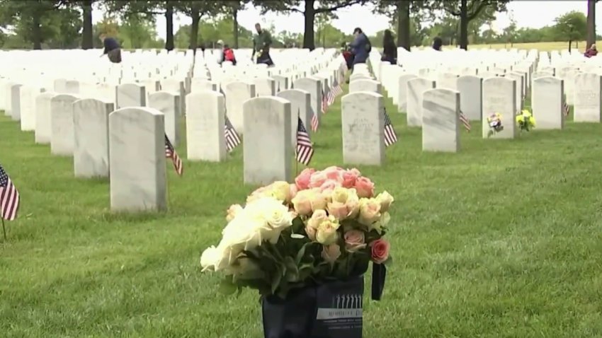 Volunteers place flowers at gravesites at Arlington National Cemetery.
