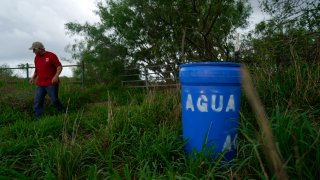 Eduardo Canales walks behind one of his blue water drops