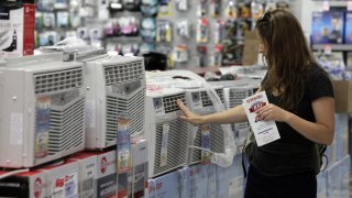 A woman looks at air conditioners for sale in a P.C. Richard & Son store, in New York, Sunday, July 1, 2012.