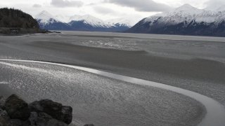 FILE - In this March 7, 2016, file photo, a ribbon of water cuts through the mud flats of Cook Inlet, just off the shore of Anchorage, Alaska. The Trump administration on Thursday, Jan. 4, 2018 moved to vastly expand offshore drilling from the Atlantic to the Arctic oceans with a plan that would open up federal waters off the Pacific coast for the first time in more than three decades. Cook Inlet is one of those areas.