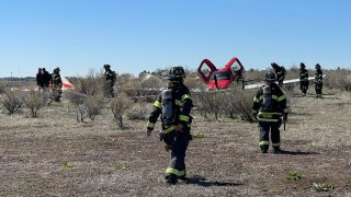 In this photo provided by South Metro Fire Rescue, emergency personnel work at the scene where a single engine plane landed after a mid-air collision near Denver, Wednesday, May 12, 2021. Federal officials say two airplanes collided but that there are no injuries. The collision between a twin-engine Fairchild Metroliner and a single-engine Cirrus SR22 happened as both planes were landing, according to the National Transportation Safety Board. Key Lime Air, which owns the Metroliner, says its aircraft sustained substantial damage to the tail section but that the pilot was able to land safely at Centennial Airport.