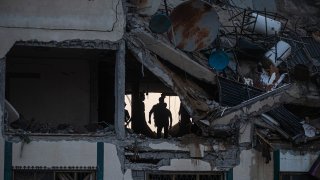 Palestinians search for survivors under the rubble of a destroyed rooftop of a residential building which was hit by Israeli missile strikes, at the Shati refugee camp in Gaza City, early Tuesday, May. 11, 2021.