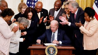 U.S. President Joe Biden is applauded as he reaches for a pen to sign the Juneteenth National Independence Day Act into law as Vice President Kamala Harris stands by in the East Room of the White House in Washington, June 17, 2021.