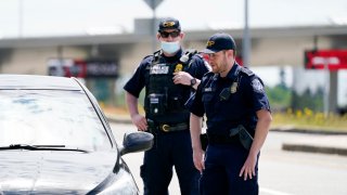 Customs and Border Protection officers direct a driver on who missed the last turn before entry into Canada on how to turn around at the Peace Arch border crossing into the U.S., Tuesday, June 8, 2021, in Blaine, Wash. The border has been closed to nonessential travel since March 2020.