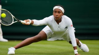Coco Gauff of the US slips on the grass as she plays a return to Britain's Francesca Jones during the women's singles first round match on day two of the Wimbledon Tennis Championships in London, Tuesday June 29, 2021.
