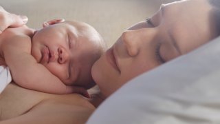 Newborn sleeping on its sleeping mother's chest.