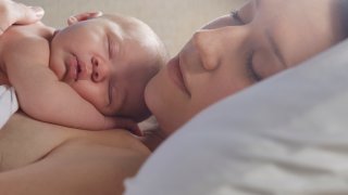 Newborn sleeping on its sleeping mother's chest.