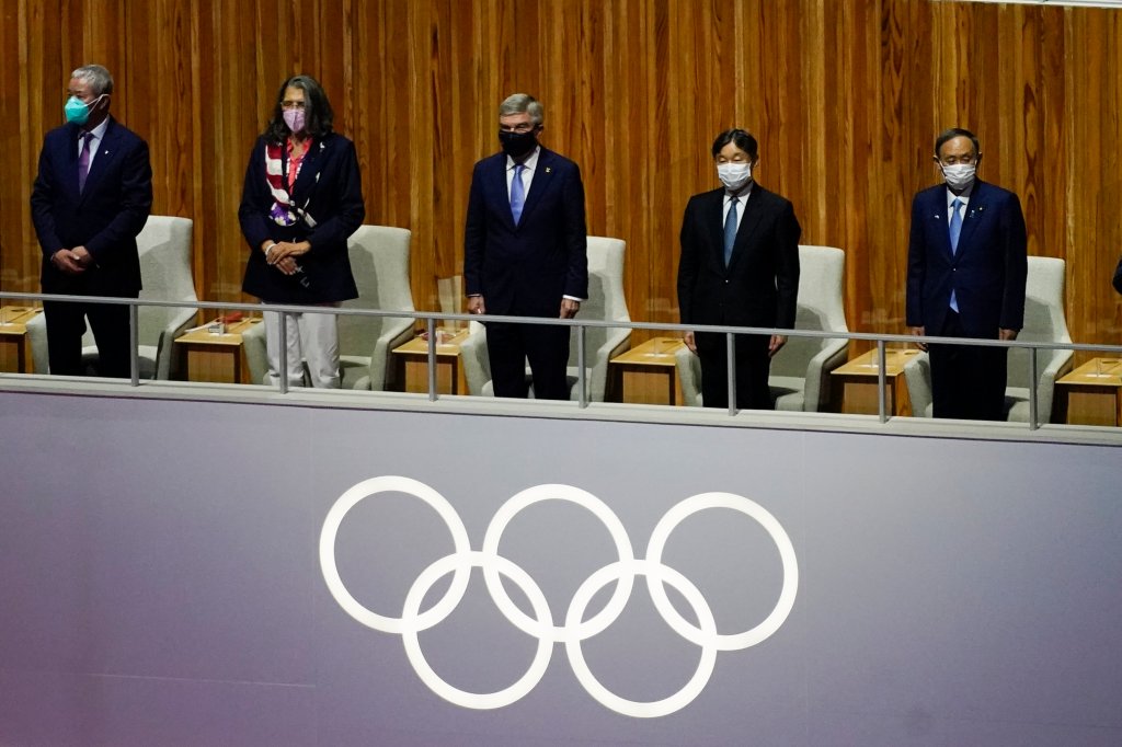 The President of the International Olympic Committee Thomas Bach and others stand during a moment of silence for victims of COVID-19 during the opening ceremony at the Olympic Stadium at the 2020 Summer Olympics, Friday, July 23, 2021, in Tokyo.