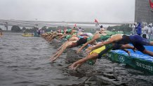 Taylor Knibb of The United States (11) and Emma Jeffcoat of Australia (22) dive into the water for the start of the women's individual triathlon competition at the 2020 Summer Olympics, Tuesday, July 27, 2021, in Tokyo, Japan.