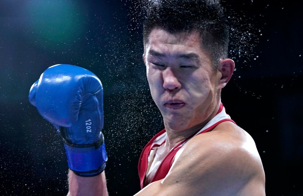 Russian Olympic Committee's Imam Khataev delivers a punch to Kazakhstan's Bekzad Nurdauletov during the men's light heavyweight 81-kg preliminaries boxing match at the 2020 Summer Olympics, Wednesday, July 28, 2021, in Tokyo, Japan.