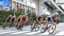 Alex Yee of Team Great Britain rides ahead of Stefan Zachaus of Team Luxembourg, Matthew Sharpe of Team Canada and other competitors during the Men's Individual Triathlon on day three of the Tokyo 2020 Olympic Games at Odaiba Marine Park on July 26, 2021 in Tokyo, Japan.