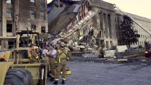 Firefighters take a break at the site of the terrorist attack at the Pentagon, Sept. 11, 2001. The terrorists struck the World Trade Center Towers in New York City and the Pentagon.