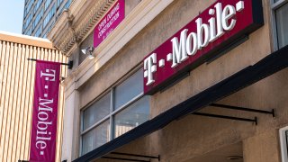 Signage for a T-Mobile store in San Francisco, California, U.S., on Tuesday, March 16, 2021. T-Mobile US Inc. is kicking off a bond sale to help finance the purchase of new high-speed spectrum licenses as carriers roll out the next generation of mobile devices.