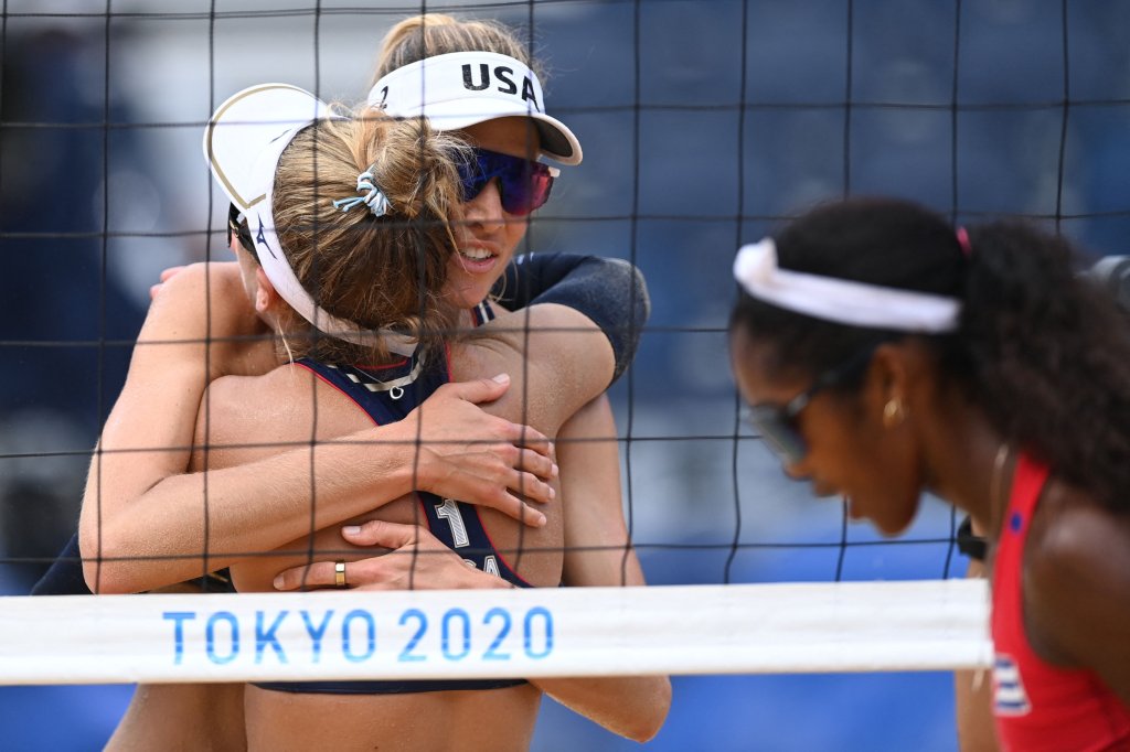 April Ross (C) and partner Alix Klineman celebrate winning, as Cuba's Lidianny Echevarria Benitez (R) walks past, after their women's beach volleyball round of 16 match between Cuba and the USA during the Tokyo 2020 Olympic Games at Shiokaze Park in Tokyo on August 2, 2021.