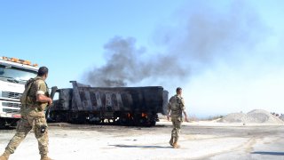 A picture taken on August 15, 2021, shows Lebanese army soldiers inspecting the site of a fuel tank explosion in the village of Tlel in Lebanon's northern region of Akkar.