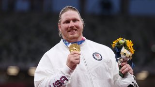 Gold medalist Ryan Crouser of Team United States holds up his medal on the podium during the medal ceremony for the Men’s Shot Put on day thirteen of the Tokyo 2020 Olympic Games at Olympic Stadium on August 05, 2021 in Tokyo, Japan.